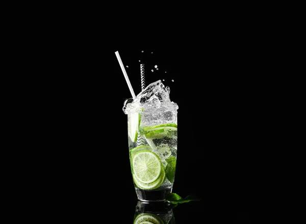 Glass of fresh mojito with splashes on dark background — Stock Photo, Image