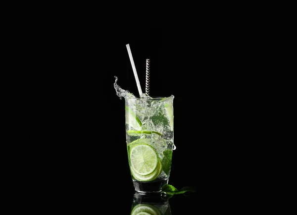 Glass of fresh mojito with splashes on dark background — Stock Photo, Image