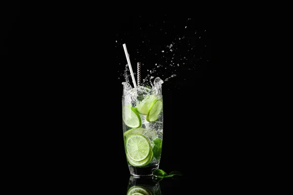 Glass of fresh mojito with splashes on dark background — Stock Photo, Image