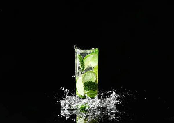 Glass of fresh mojito with splashes on dark background — Stock Photo, Image