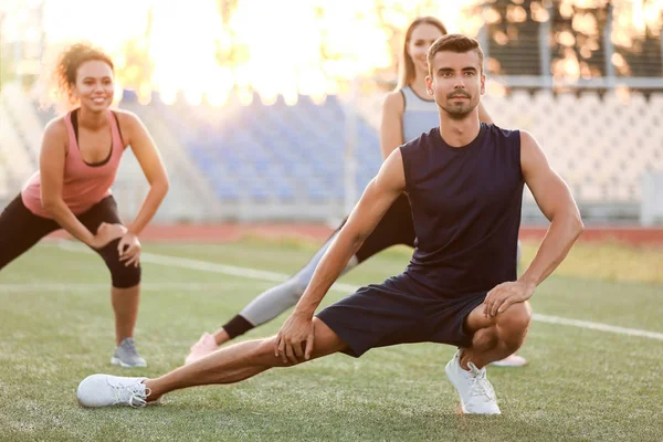 Group of sporty young people training at the stadium — Stock Photo, Image