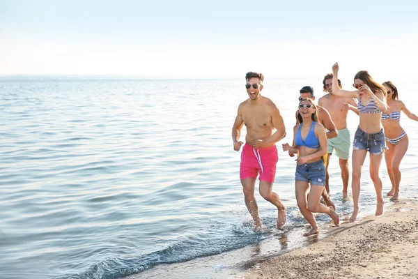 Amigos correndo na praia do mar — Fotografia de Stock