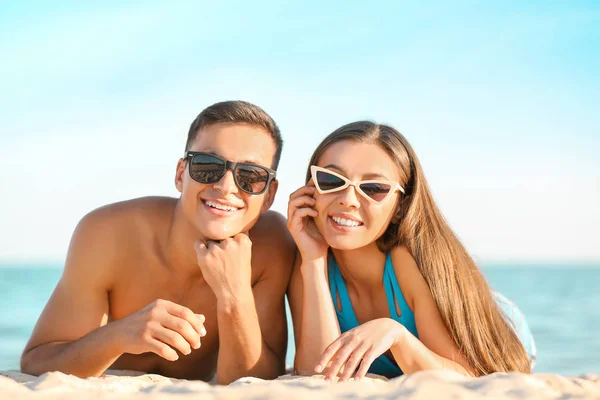 Jovem casal descansando na praia do mar — Fotografia de Stock