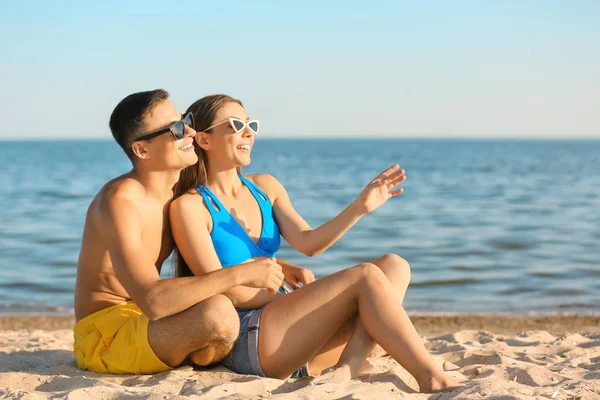 若いカップルが海のビーチで休んでいて — ストック写真