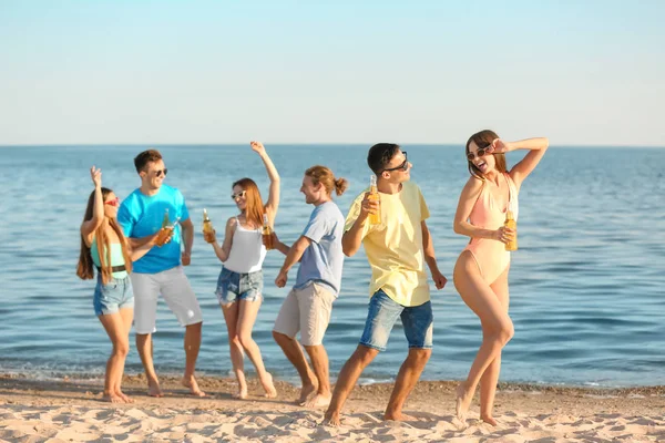Amigos bebendo cerveja na praia do mar — Fotografia de Stock