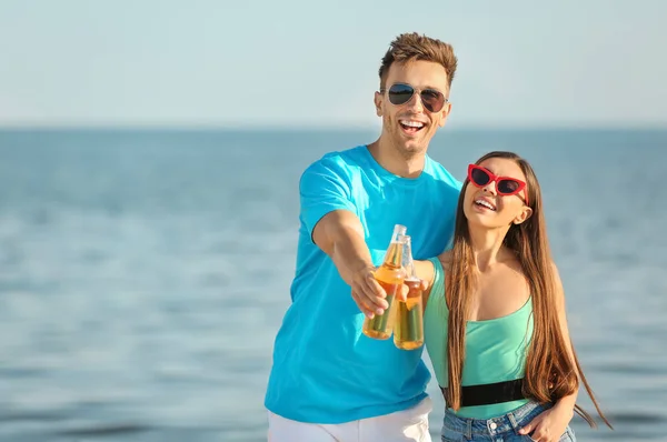 Friends drinking beer on sea beach — Stock Photo, Image