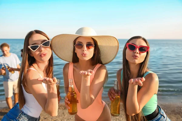 Friends drinking beer on sea beach — Stock Photo, Image