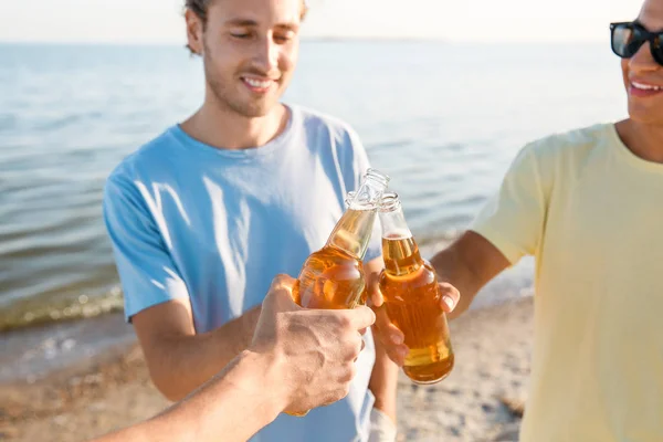 Amici che bevono birra sulla spiaggia di mare — Foto Stock