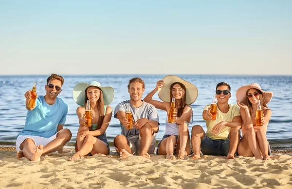Friends drinking beer on sea beach — Stock Photo, Image