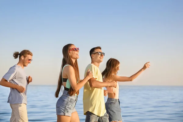 Amigos correndo na praia do mar — Fotografia de Stock