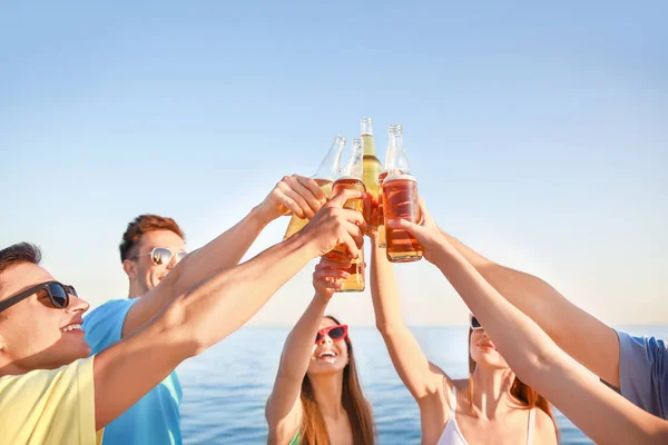 Amici che bevono birra sulla spiaggia di mare — Foto Stock
