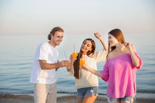 Amigos bebiendo jugo en la playa del mar —  Fotos de Stock