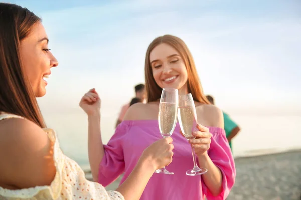 Friends drinking champagne on sea beach — Stock Photo, Image
