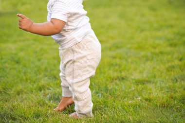 Sevimli küçük bebek açık havada yürümeyi öğreniyor