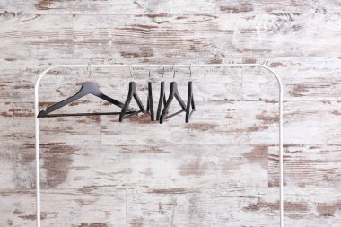 Ahşap duvara asılı elbise askılarıyla dizilin.