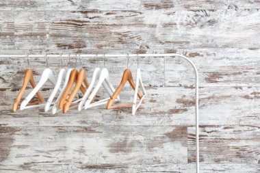 Ahşap duvara asılı elbise askılarıyla dizilin.