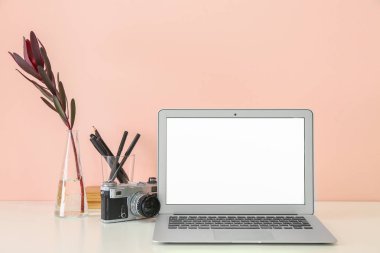 Renk duvarının yanında dizüstü bilgisayarı olan rahat bir iş yeri