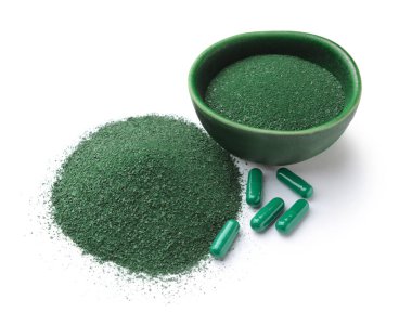 Sarmaşık tozu ve beyaz arka planda haplarla dolu bir kase.