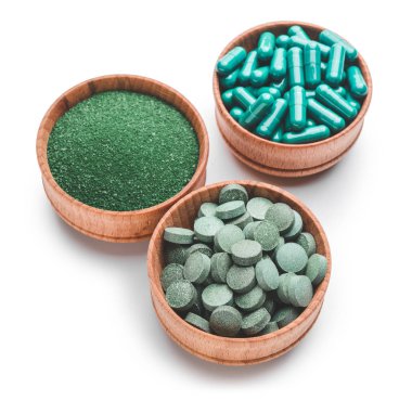 Sarmaşık tozlu kaseler ve beyaz arka planda haplar.