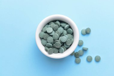 Arka planda spirulina hapları olan bir kase
