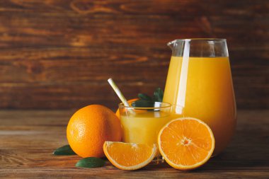 Tahta masada bir bardak taze portakal suyu.