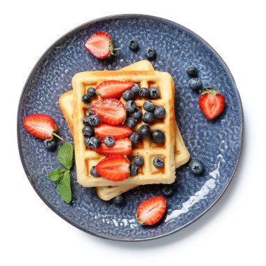 Beyaz arka planda lezzetli waffle ve böğürtlen tabağı