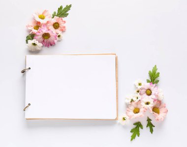 Beyaz arka planda çiçekli ve defterli güzel kompozisyon