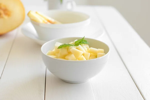 Bowl with fresh melon pieces on white table — Stock Photo, Image