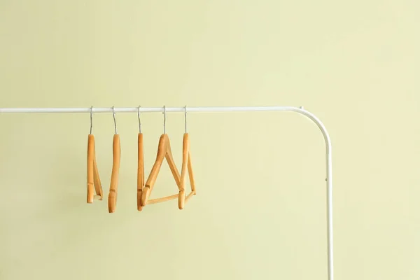 Rack met kleding hangers op kleur achtergrond — Stockfoto