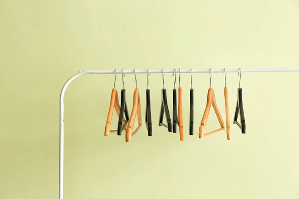 Rack with clothes hangers on color background — Stock Photo, Image