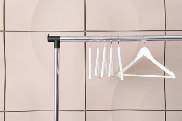 Rek met kleerhangers tegen lichte wand — Stockfoto