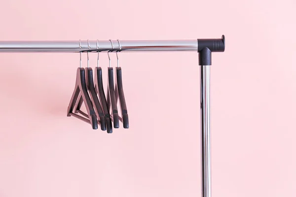 Rack met kleding hangers op kleur achtergrond — Stockfoto