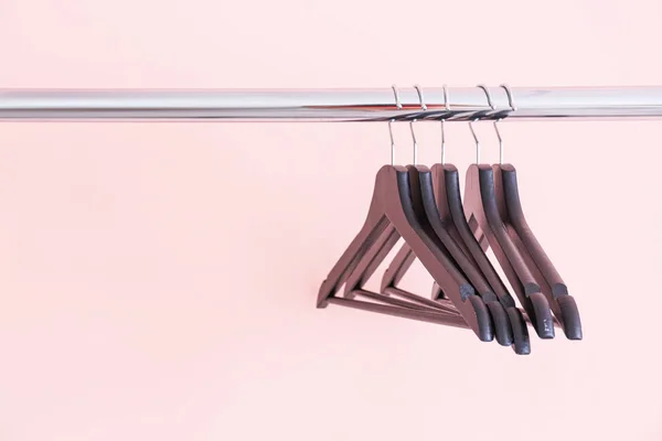 Rack met kleding hangers op kleur achtergrond — Stockfoto