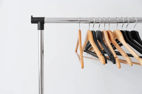 Rack med kläder hängare på ljus bakgrund — Stockfoto