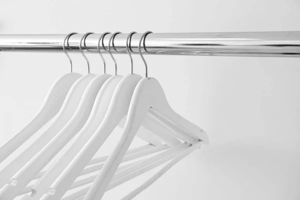 Rack with clothes hangers on light background — Stock Photo, Image