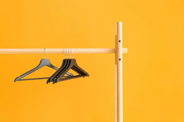 Rack with clothes hangers on color background — Stock Photo, Image