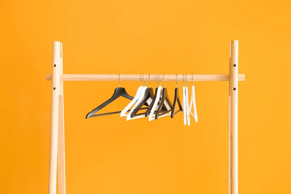 Rack with clothes hangers on color background — Stock Photo, Image