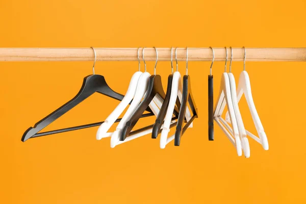 Стойка с вешалками для одежды на цветном фоне — стоковое фото