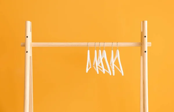 Rack with clothes hangers on color background — Stock Photo, Image
