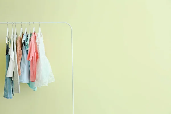 Bastidor con ropa colgante sobre fondo de color — Foto de Stock