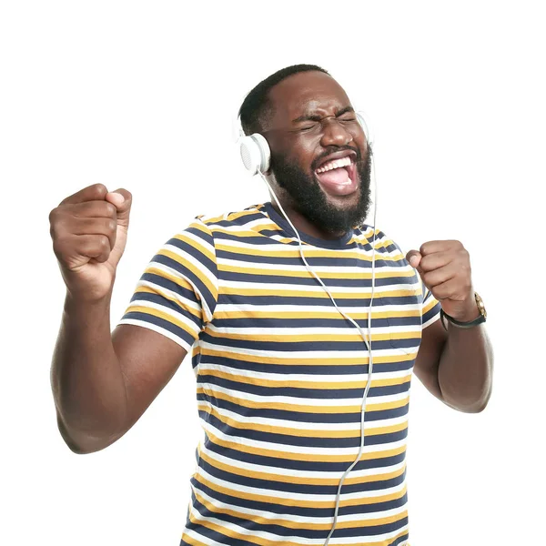 Happy African-American man listening to music on white background — Stock Photo, Image
