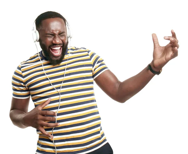 Happy African-American man listening to music on white background — Stock Photo, Image