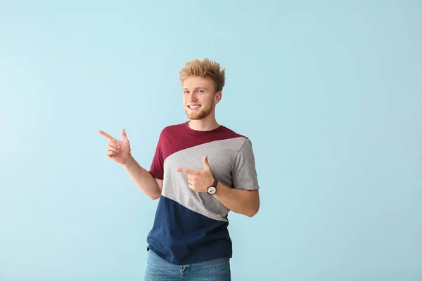 Retrato de un joven señalando algo sobre el fondo de color — Foto de Stock