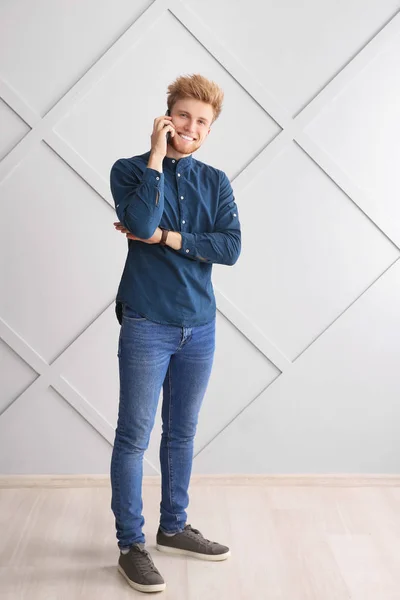 Πορτραίτο του νεαρού άνδρα μιλώντας από κινητό τηλέφωνο κοντά σε γκρι τοίχο — Φωτογραφία Αρχείου