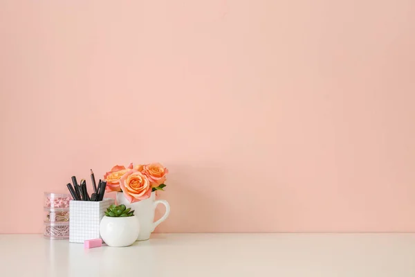 Cómodo lugar de trabajo con papelería y decoración cerca de la pared de color —  Fotos de Stock