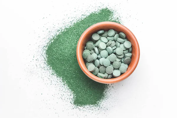 Bowl with spirulina pills and powder on white background — Stock Photo, Image