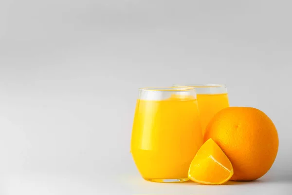 Gläser mit frischem Orangensaft auf hellem Hintergrund — Stockfoto