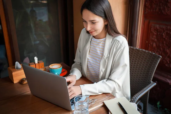 Young woman with laptop in cafe — Stock Photo, Image