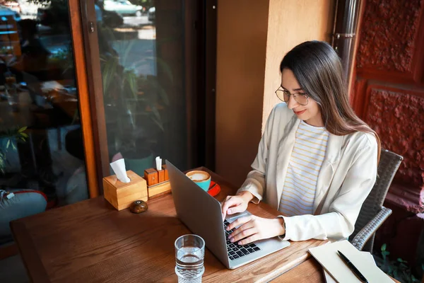 Young woman with laptop in cafe — Stock Photo, Image