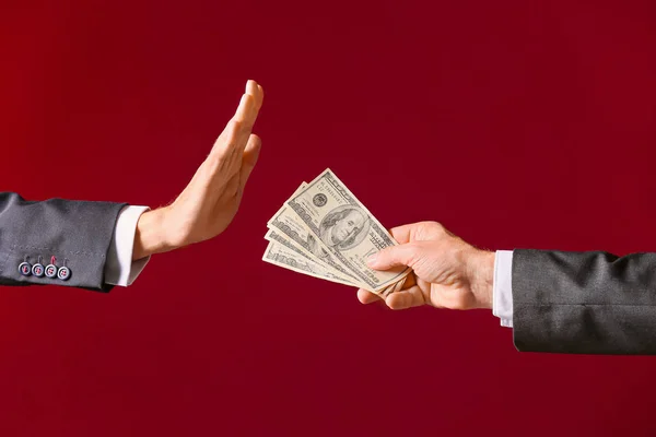 Businessman refusing to take bribe against color background — Stock Photo, Image